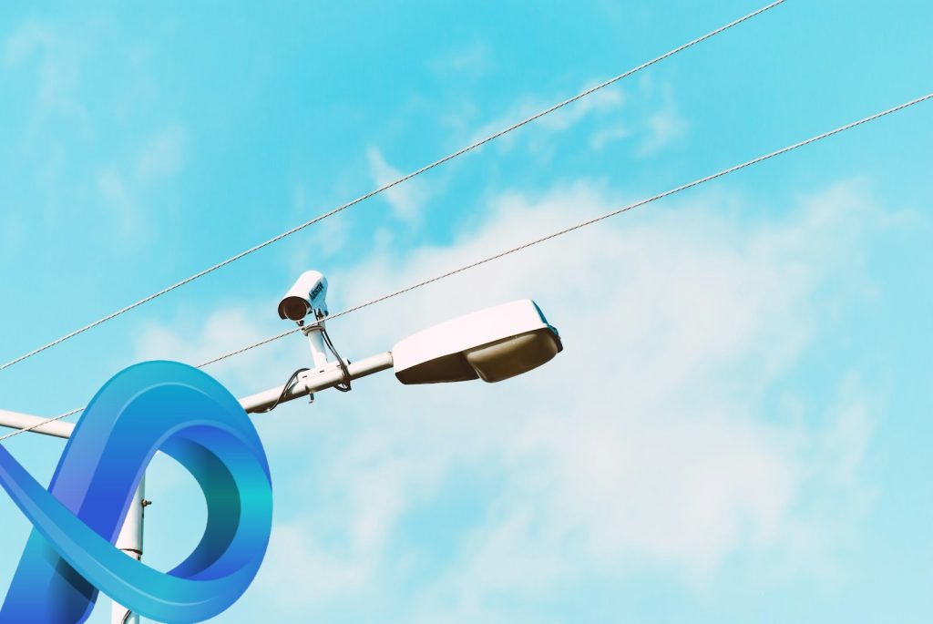Caméra de surveillance accrochée à un poteau électrique.
