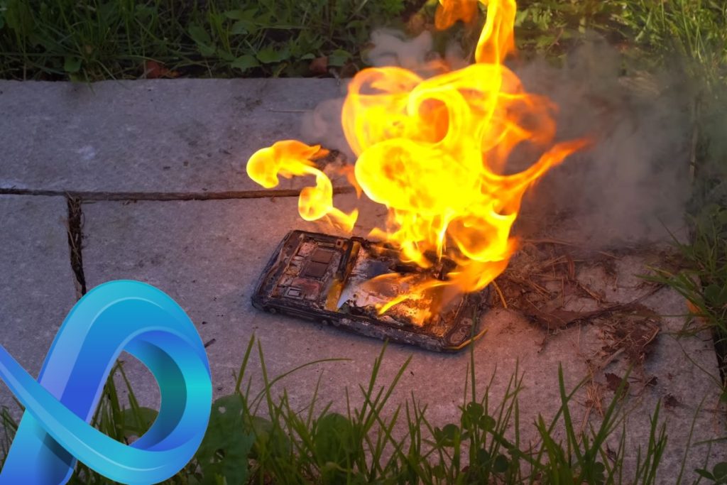 Un téléphone portable est en feu au sol.