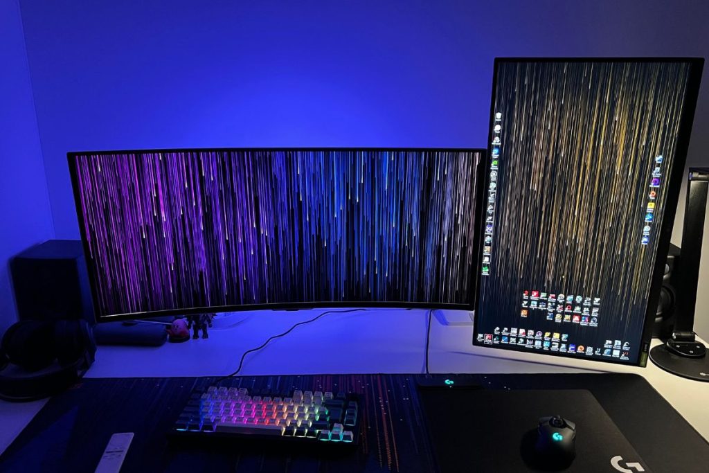 Un bureau avec deux moniteurs et un clavier.