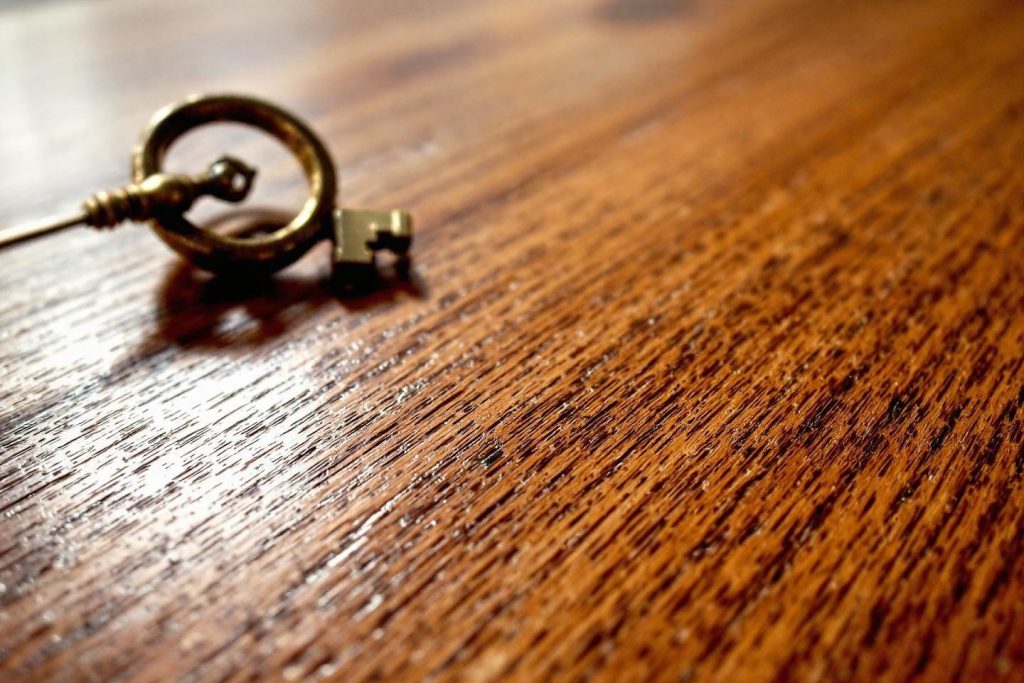 Gros plan d'une ancienne clé métallique sur surface en bois